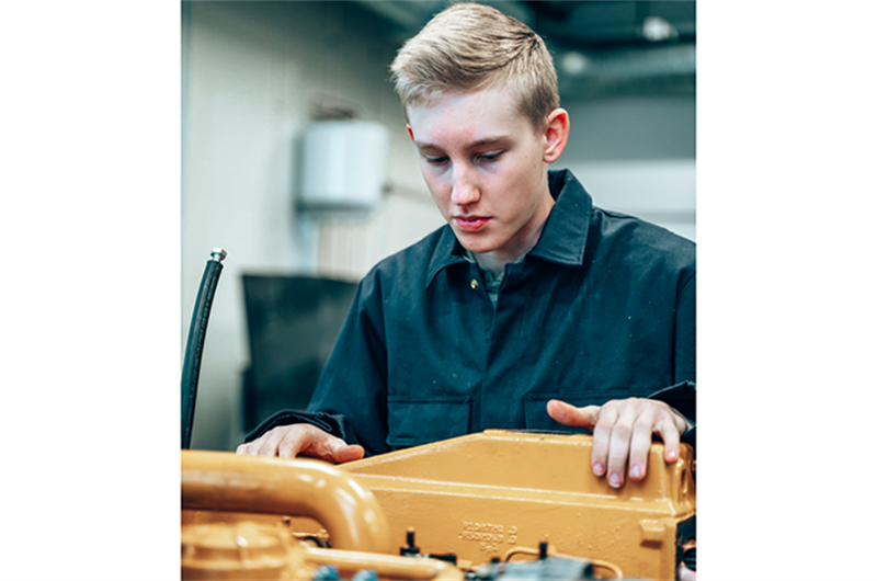 Ungdom som reparerer motor.