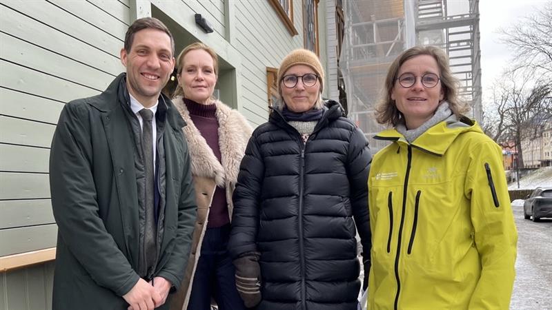 Gruppe bilde av  klima- og miljøminister Andreas Bjelland Eriksen, riksantikvar Hanna Geiran, arkiktekt ved Byantikvaren Trondheim kommune Elisabeth Kars og seniorarkitekt Trøndelag fylkeskommune Heike Schmidtko utenfor Kjøpmannsgata 15.
