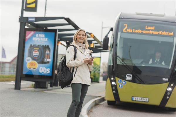 Bilde av dame som står foran buss. Foto: Ronny M. Danielsen