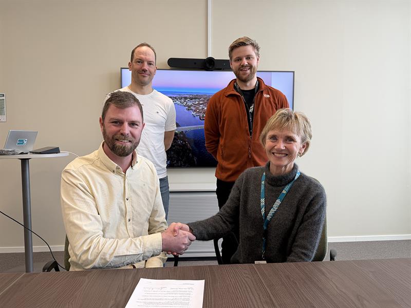 Ansatte signerer avtale om brubygging. Bilde