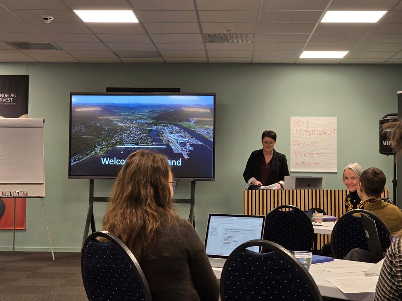 Ordføreren i Orkland står ved et lerret og holder en presentasjon for publikum.
